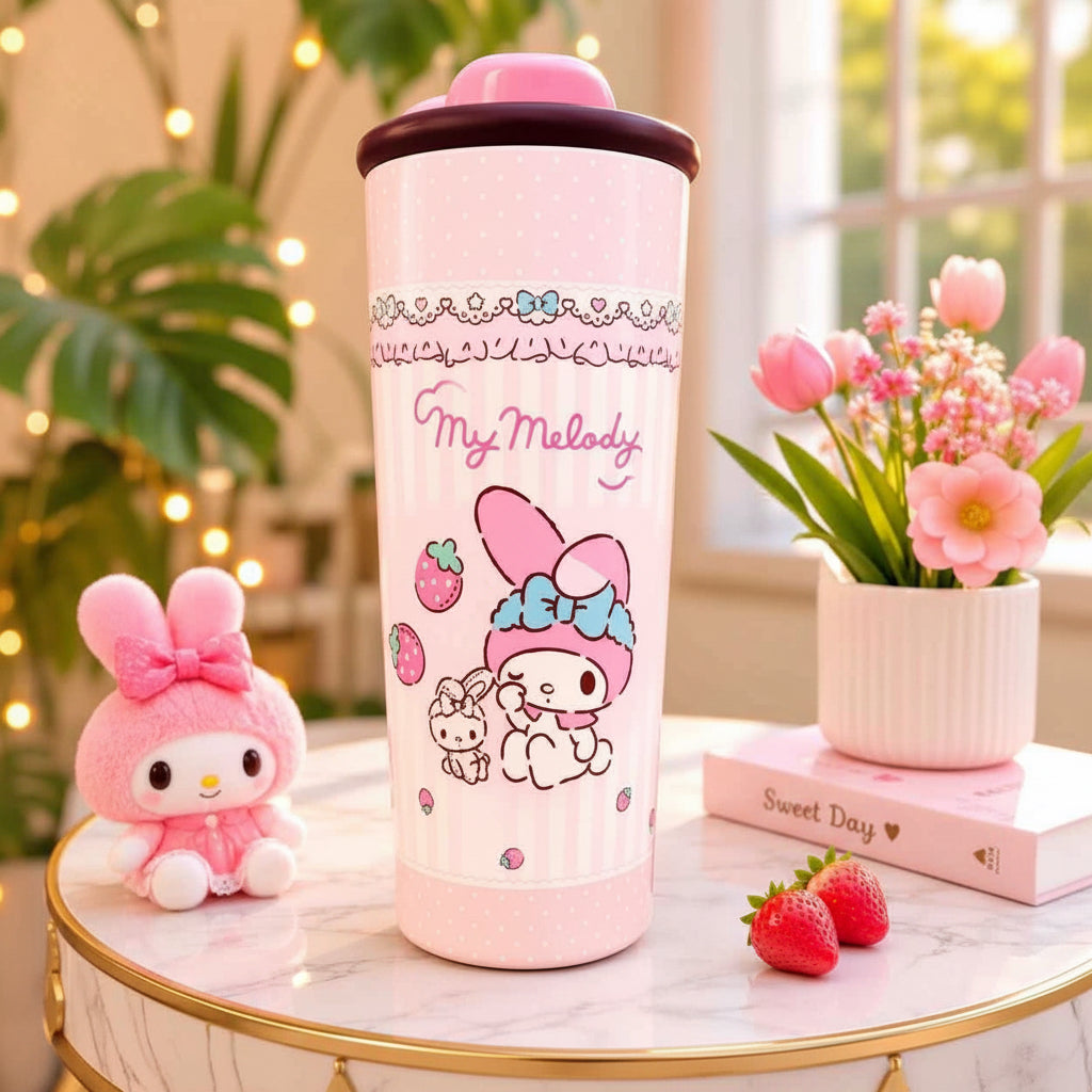 A pink My Melody insulated tumbler with a matching pink lid, displayed on a marble table with decorative props including a plush toy, flowers, and strawberries in a bright indoor setting.